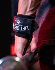 Gros plan sur le crochet de tirage Warrior Gear accroché à une barre olympique lors d'un exercice de musculation du dos.
