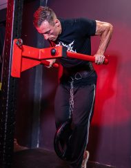 Pratiquant réalisant une répétition de dips lestés avec un disque de poids accroché à la ceinture de lestage Warrior Gear.