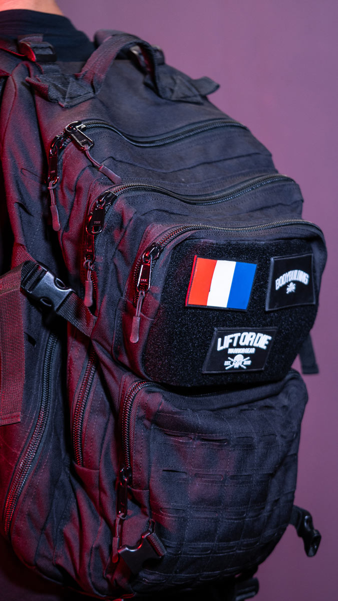 Nahaufnahme der robusten Reißverschlüsse, des MOLLE-Systems und des Klettverschlussbereichs des taktischen Rucksacks Warrior Gear.