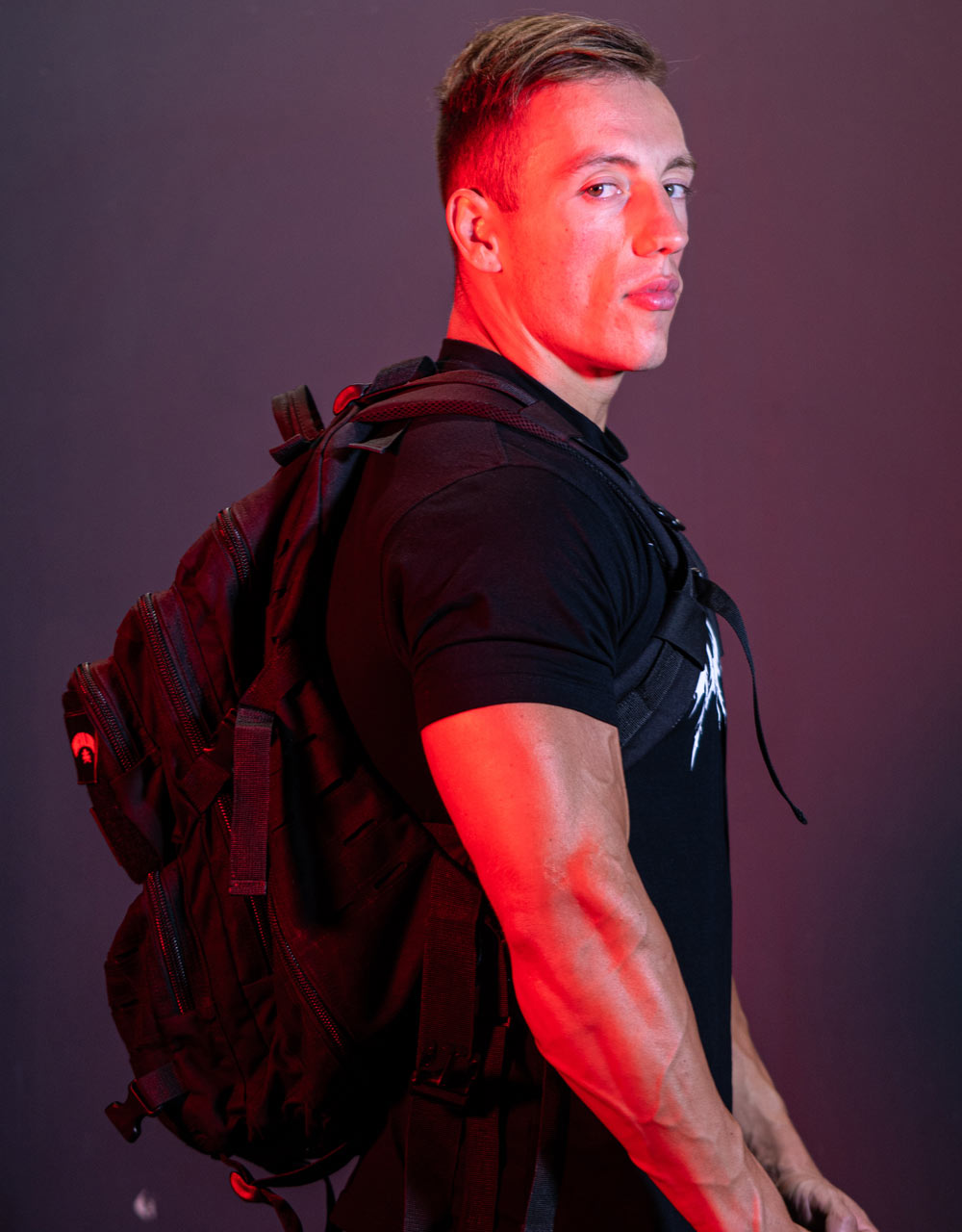 Seitenansicht des großen schwarzen Gewichtheberrucksacks, die die Dicke der Fächer und der Kompressionsriemen zeigt.