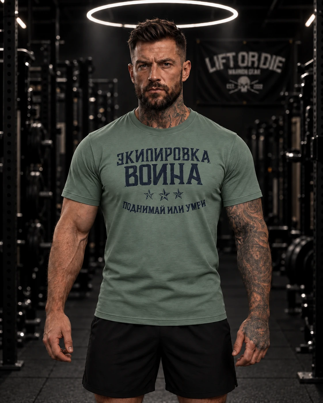 Sportowiec ubrany w taktyczną zieloną koszulkę kulturystyczną z przodu, z logo Warrior Gear Lift or Die napisanym cyrylicą rosyjską.