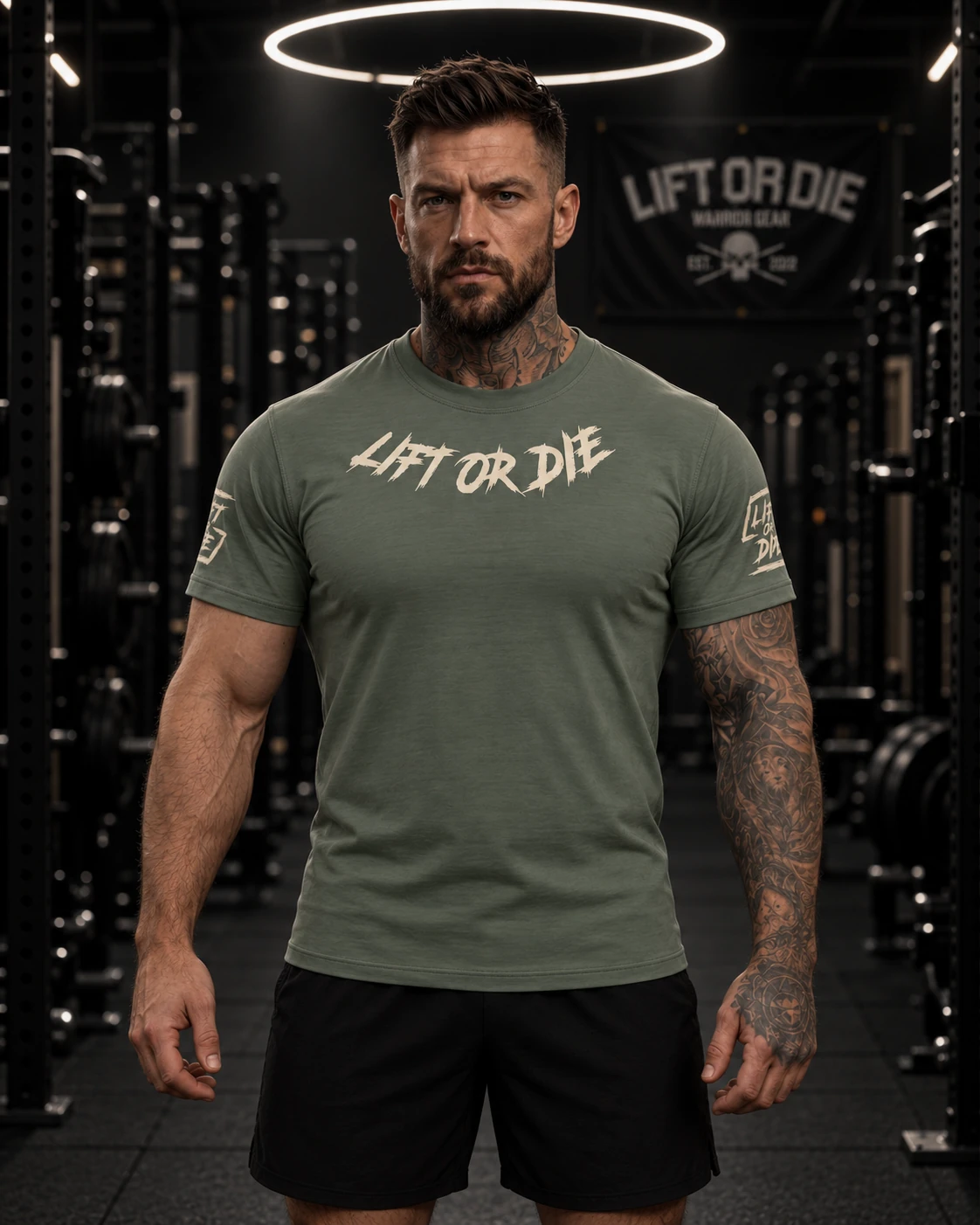 Muskulöser Athlet in einem grünen Tactical Lift or Die T-Shirt der Marke Warrior Gear, der in die Kamera blickt.