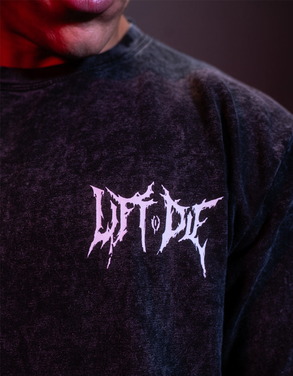 Primo piano della stampa in stile Death Metal Lift or Die sulla maglietta da bodybuilding sbiadita della Warrior Gear.