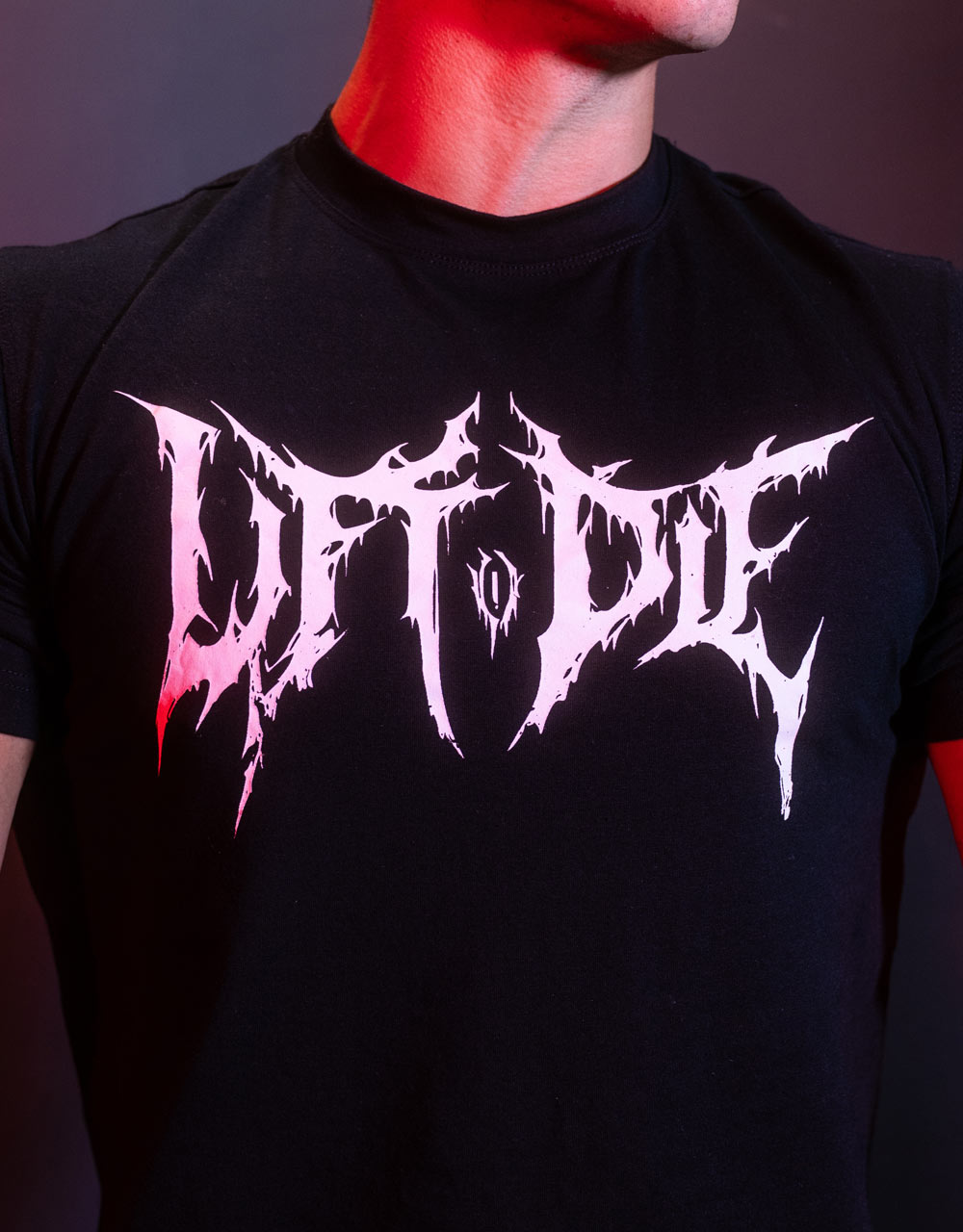 Zoom in on the white and pink Lift or Die style logo Death Metal screen print on a black t-shirt.