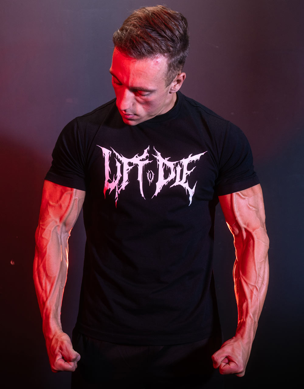 Muscular man contracting his arms while wearing the Warrior Gearstretchy, form-fitting sports t-shirt.
