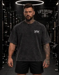AthlĂšte portant le t-shirt de musculation oversize dĂ©lavĂ© noir de face, avec un discret logo Lift or Die style death metal sur le cĆur.